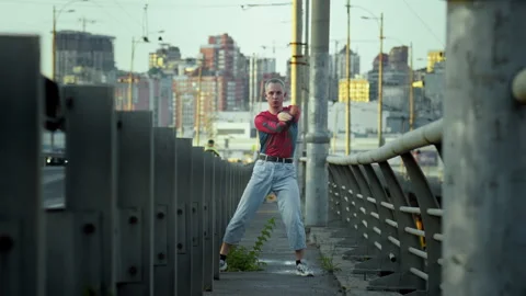 Bridge Grooves: Energetic Freestyle Dancing by a Young Man in the Urban Landscap Stockbeeldmateriaal 245892809