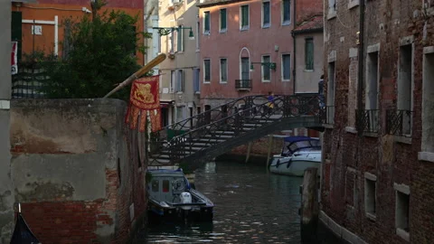 Bridge over a canal in Venice with a flag Stock Footage 219994316