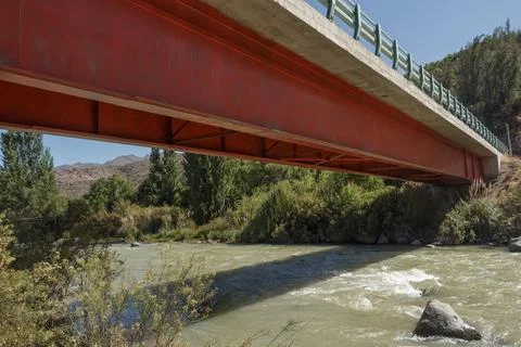 Bridge over a clean river formed by the melting ice of the Andes mountais, Chile Stock Photos