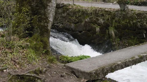 A bridge over a high debit mountain river Stockbeeldmateriaal 88830854