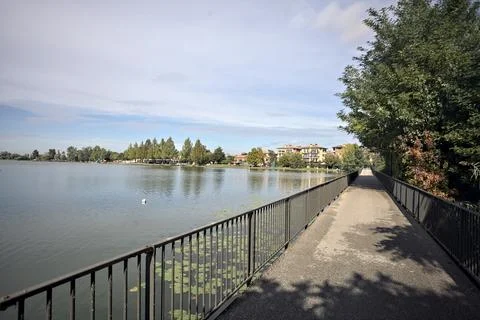 Bridge over a lake with tree arching near it on a sunny day in the italian .. Stock Photos