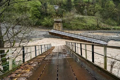 A bridge over a mountain river destroyed by water Stock Photos