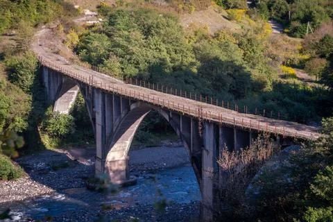 A bridge over a mountain river with high banks 스톡 사진