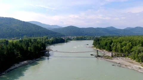 Bridge over the mountain river Katun in the Altai. Drone shooting on a sunny day Stock Footage 143476796