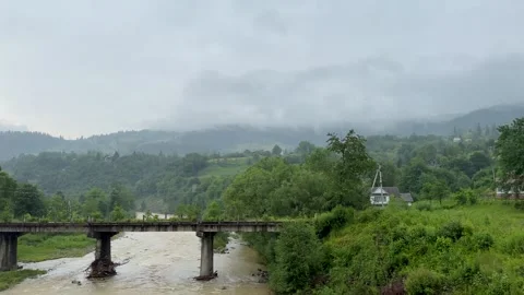 Bridge over mountain river, landscape. Cloudy foggy day, rainy weather. Video stock 249897774