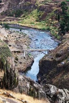 Bridge over a mountain river Stock Photos