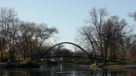 Bridge over pond with ducks, sunny fall day Stock Footage 12371776