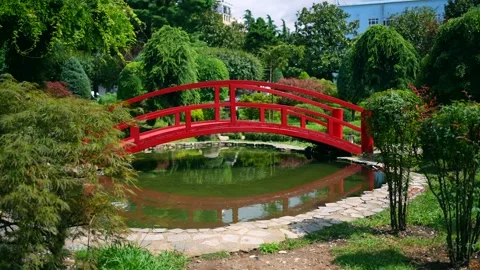 Bridge over a pond in a small garden ,decorative elements Japanese style Stockbeeldmateriaal 247136840