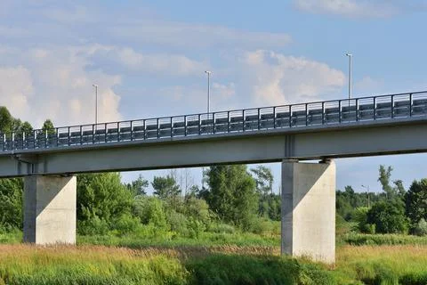 Bridge over the river between trees on a sunny day. Summer. Day. Stock Photos