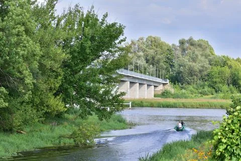 Bridge over the river between trees on a sunny day. Summer. Day. Stock Photos