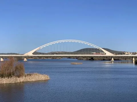 Bridge over river with clear blue sky and distant hills Fotos Stock
