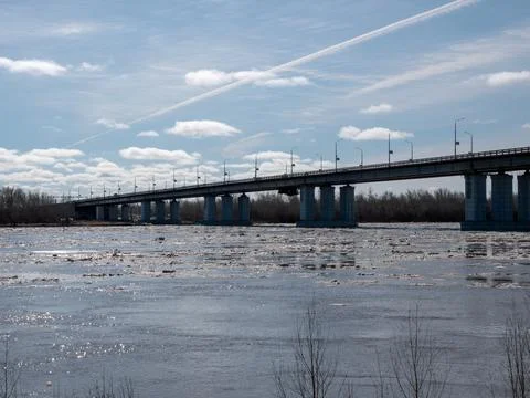 Bridge over river with ice drift spring landscape blue sky with light clouds  Stock Photos