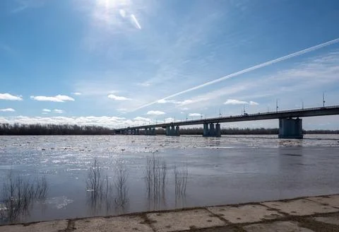 Bridge over river with ice drift spring landscape blue sky with light cloud.. Stock Photos