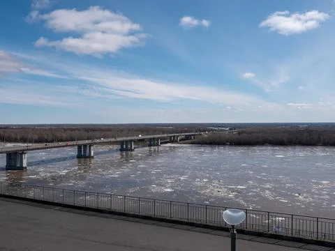 Bridge over river with ice drift spring landscape blue sky with light cloud.. Stock Photos