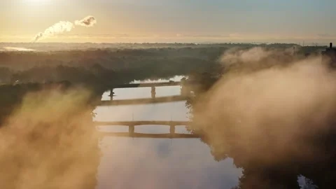 Bridge over a River with Low Flying Clouds Stock Footage 250122640