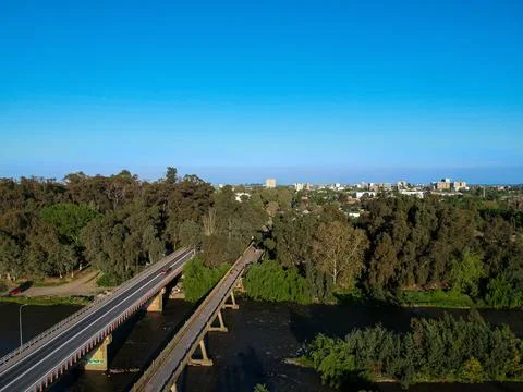 Bridge over river Rio Claro on Talca, Chile with a little forest in the middle o Stock Photos