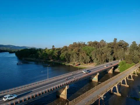 Bridge over river Rio Claro on Talca, Chile with a little forest in the middle o Stock Photos