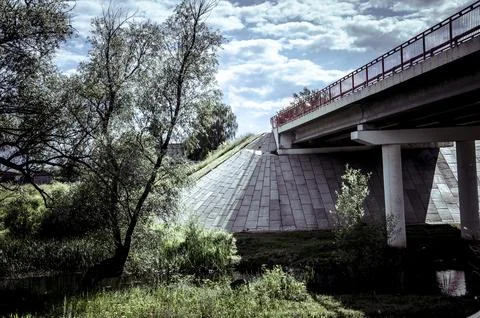 Bridge over the river in the summer. View from below. Toned. Stock Photos