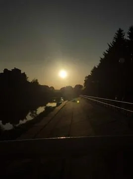 A bridge over a river with the sun setting in the background Stock Photos