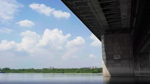 The bridge over the river. There are trees and houses in the background. Vídeos de archivo 245425618