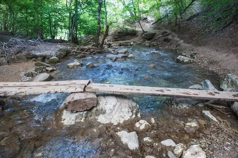 Bridge over a small mountain river Stock Photos