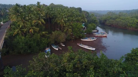 Bridge over a small tropical river, a few boats pulled ashore. Aerial view. Stock Footage 85112116