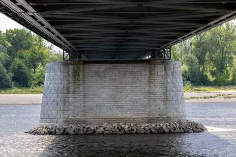 Bridge pier made of stone blocks stands in river water. Фото
