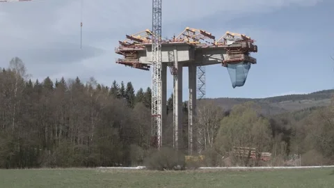 Bridge pier under construction with scaffolding in a green valley landscape Stock Footage 333396585