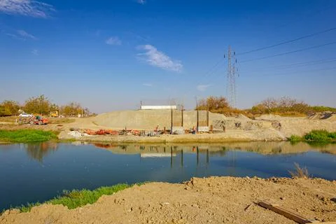 Bridge poles under construction over the river, works on building site Stock Photos