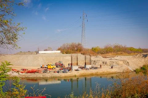 Bridge poles under construction over the river, works on building site Stock Photos
