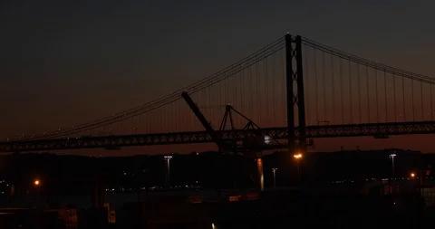 Bridge Ponte 25 de Abril over the Tagus river in Lisbon; night lights. Sunset Stock Footage 104561087