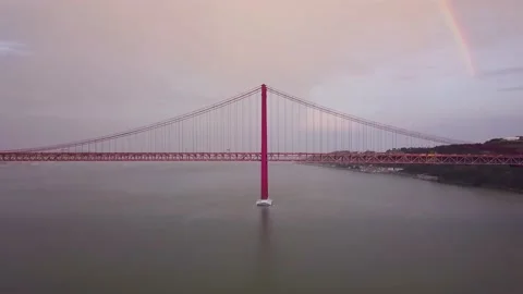 Bridge Ponte 25 de Abril with rainbow and Cargo ship 库存影片 196840205