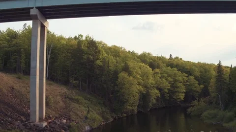 Bridge Pull Back Reveal From Below and Fly Down River Stock Footage 71328639