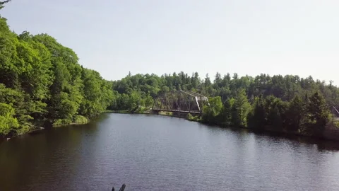 A bridge on a river in the woods Stock Footage 144790734