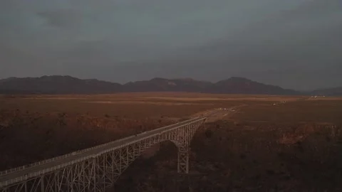 A bridge sits in a desert valley at sunset with New Mexico mountains behind Stock Footage 167663909