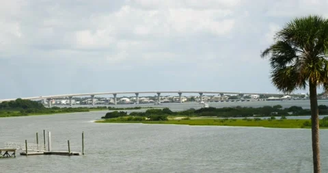 Bridge spanning across bay with palm tree blowing in the wind St Augustine Fl Stock Footage 210305298
