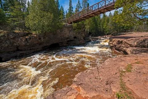 Bridge Spanning a Dramatic Cascade Stockfoto's