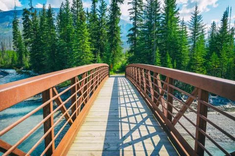 Bridge spanning a mountain river Stock Photos