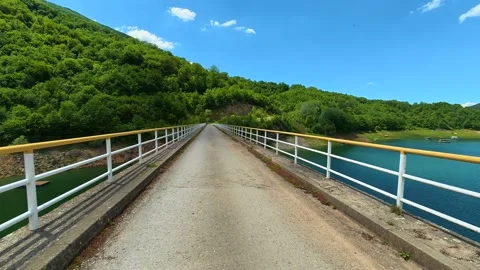 Bridge spans calm lake surrounded by lush green hills. Zavoj Lake, Serbia Vídeos de archivo 337488019