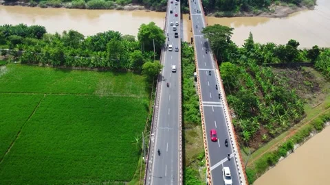 Bridge spans muddy river, connecting green fields Видео 336269782