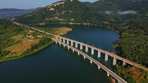 Bridge spans a river with green hills in the background near a village Stock Footage 340381880
