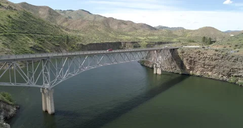 A bridge spans a river with a mountain in the background Stock Footage 292045798
