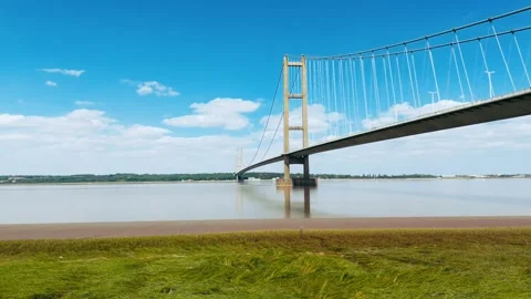 Bridge spans wide river under clear sky Видео 343519768