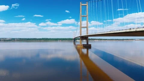 Bridge spans wide river under bright sky Video stock 343529147