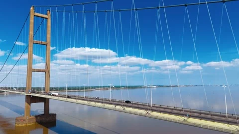 Bridge spans wide river under bright blue sky Vidéo 343539419