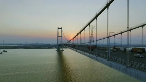 Bridge traffic and suspension cables beside the setting sun at Nansha Bridge 스톡 동영상 346744892