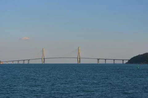 A bridge with two vertical pylons arching over a bay. Stock Photos