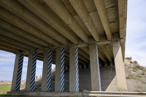 Bridge underpass with patterned support columns against a clear sky 库存照片