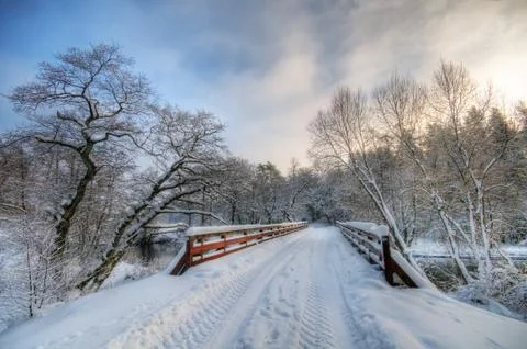 Bridge in winter forest during sunset, lots of snow 스톡 사진