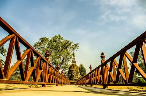 A bridge with a wooden railing and a tree in the background Stock Photos